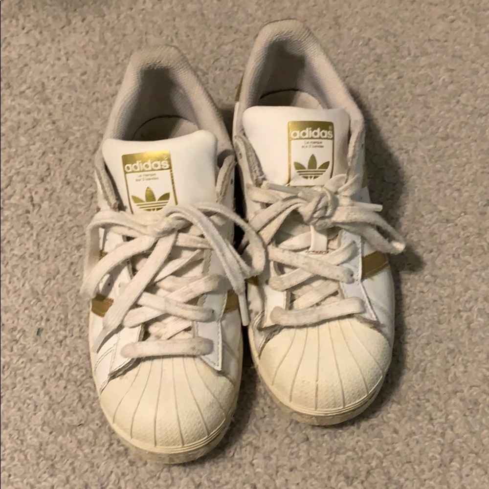 Gold and white adidas superstars